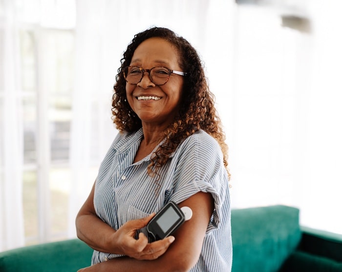 Persoon gebruikt bloedglucosemeter voor dagelijkse controle van bloedsuikerwaarden